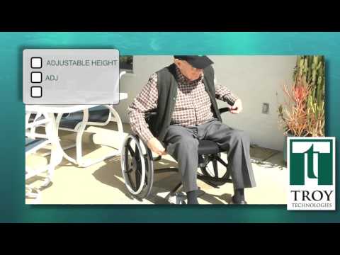 User maneuvering FLUX 360 wheelchair with feet on hardwood floor